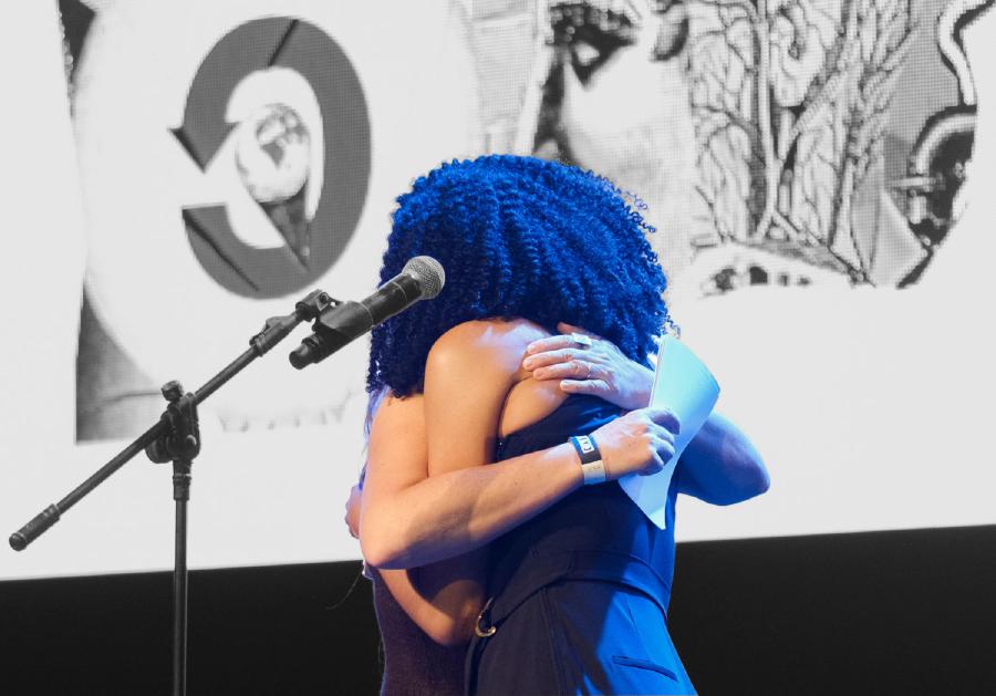 Adele Godoy Vrana and Siko Bouterse hugging after their talk at Creative Commons Global Summit 2019